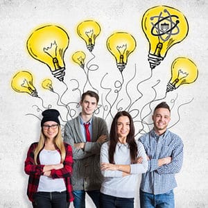 Attractive young team on concrete background with drawn light bulbs. Creative idea concept